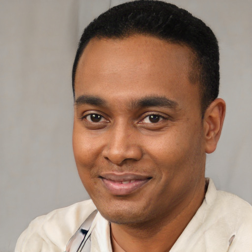 Joyful latino young-adult male with short  black hair and brown eyes