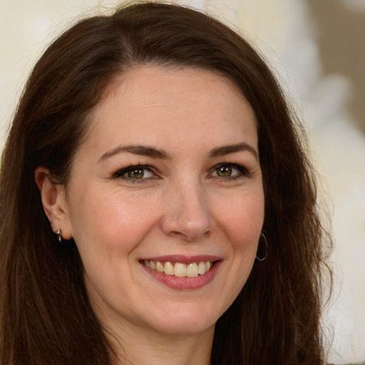 Joyful white young-adult female with long  brown hair and green eyes