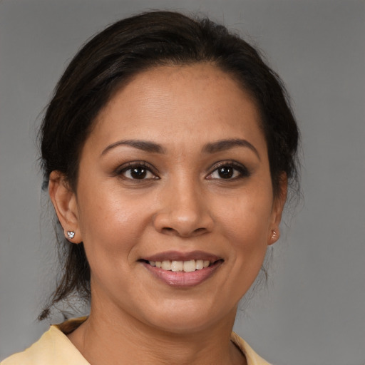Joyful latino adult female with medium  brown hair and brown eyes