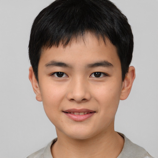 Joyful asian child male with short  black hair and brown eyes