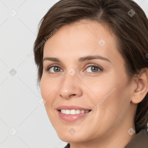 Joyful white young-adult female with medium  brown hair and grey eyes