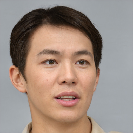Joyful asian young-adult male with short  brown hair and brown eyes