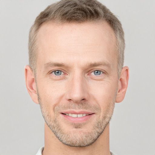 Joyful white adult male with short  brown hair and grey eyes