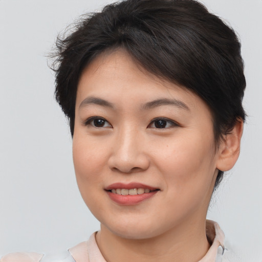 Joyful asian young-adult female with short  brown hair and brown eyes