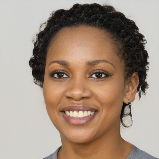 Joyful black young-adult female with long  black hair and brown eyes