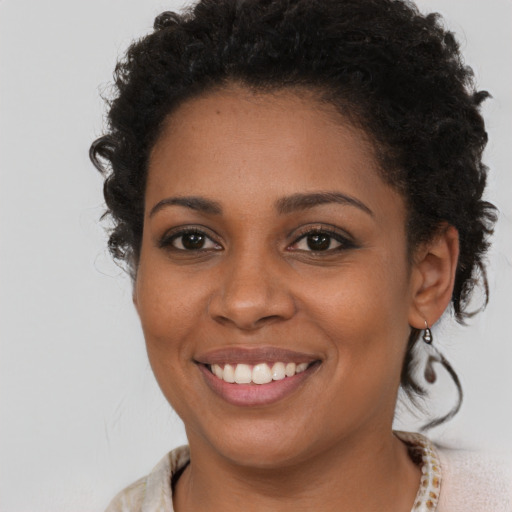 Joyful black young-adult female with long  brown hair and brown eyes