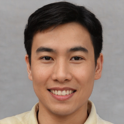 Joyful asian young-adult male with short  brown hair and brown eyes