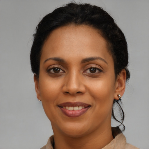 Joyful black young-adult female with short  black hair and brown eyes