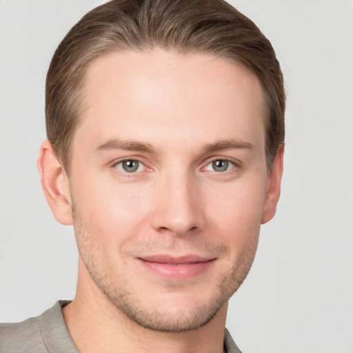 Joyful white young-adult male with short  brown hair and grey eyes