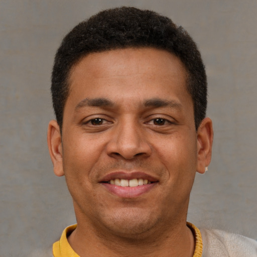 Joyful latino young-adult male with short  brown hair and brown eyes