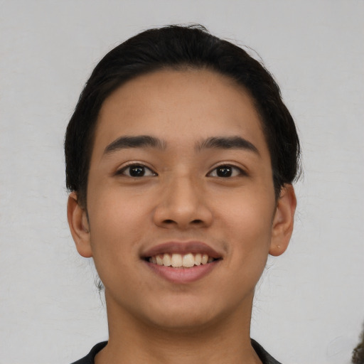 Joyful latino young-adult male with short  black hair and brown eyes