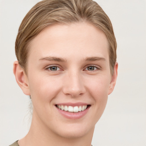 Joyful white young-adult female with short  brown hair and grey eyes