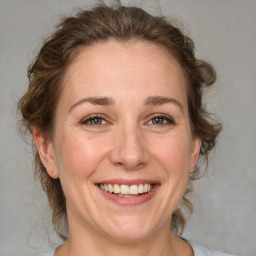 Joyful white adult female with medium  brown hair and brown eyes