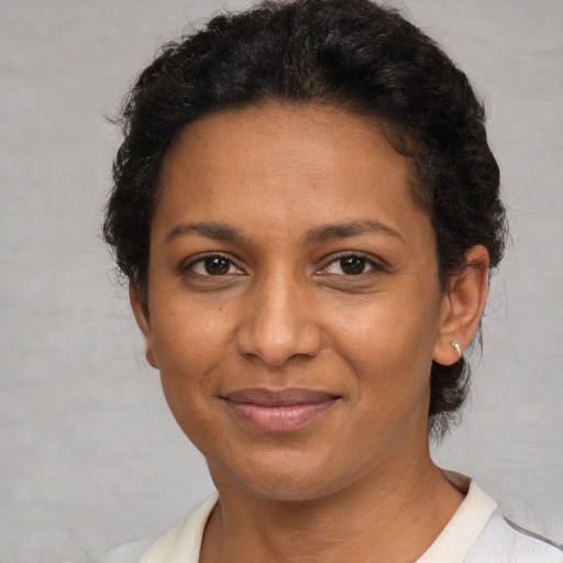 Joyful black young-adult female with short  brown hair and brown eyes