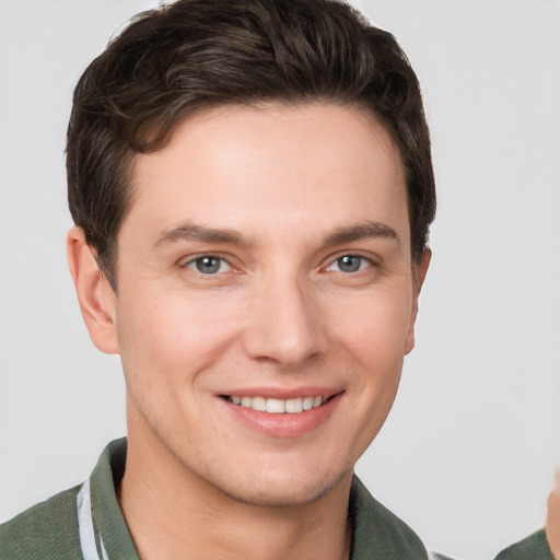 Joyful white young-adult male with short  brown hair and grey eyes