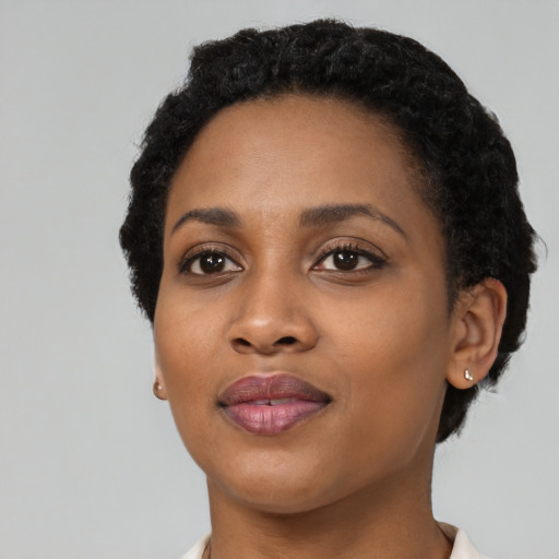 Joyful black young-adult female with short  black hair and brown eyes