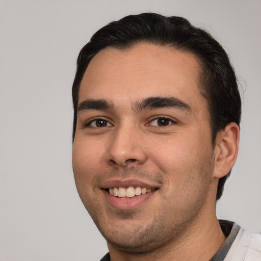 Joyful white young-adult male with short  black hair and brown eyes