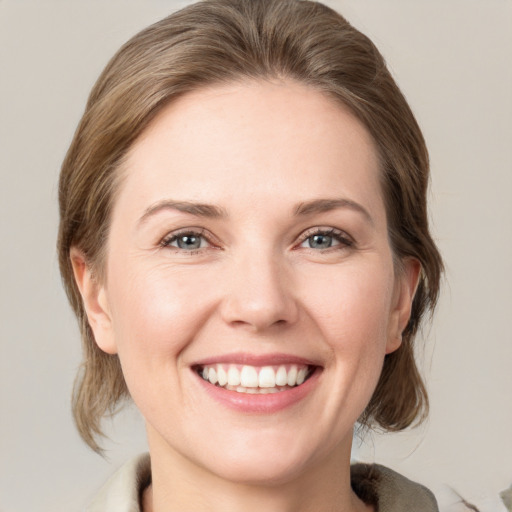 Joyful white young-adult female with medium  brown hair and green eyes