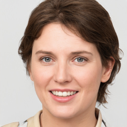 Joyful white young-adult female with medium  brown hair and grey eyes