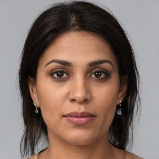 Joyful latino young-adult female with medium  brown hair and brown eyes