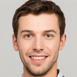 Joyful white young-adult male with short  brown hair and grey eyes