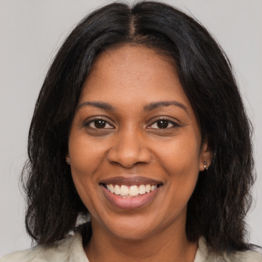 Joyful black young-adult female with medium  brown hair and brown eyes