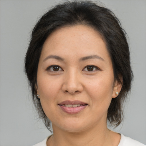 Joyful asian adult female with medium  brown hair and brown eyes