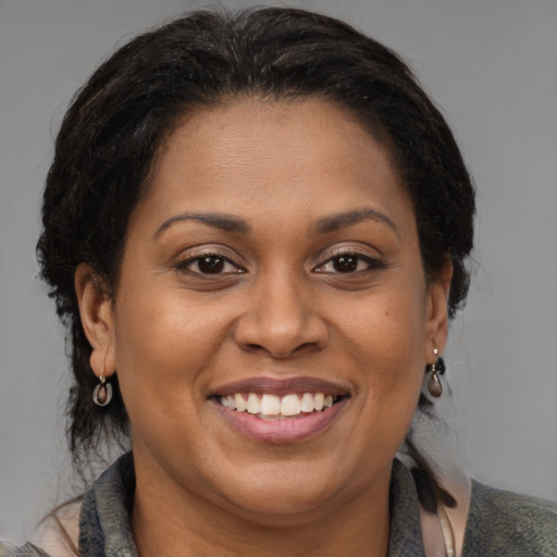 Joyful black adult female with medium  brown hair and brown eyes