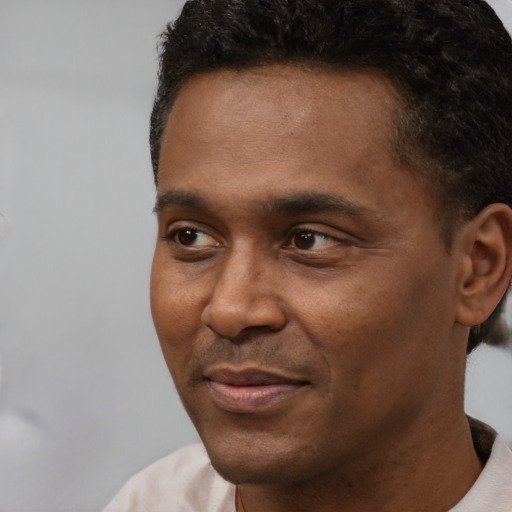 Joyful latino adult male with short  black hair and brown eyes