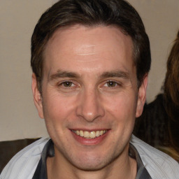 Joyful white adult male with short  brown hair and brown eyes