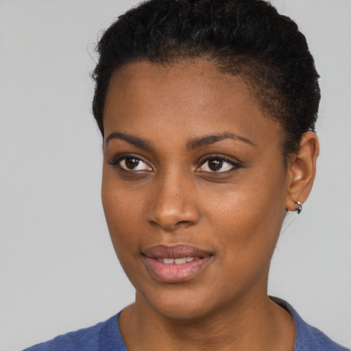 Joyful black young-adult female with short  brown hair and brown eyes