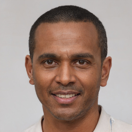Joyful latino adult male with short  black hair and brown eyes