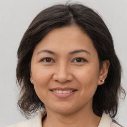 Joyful white adult female with medium  brown hair and brown eyes