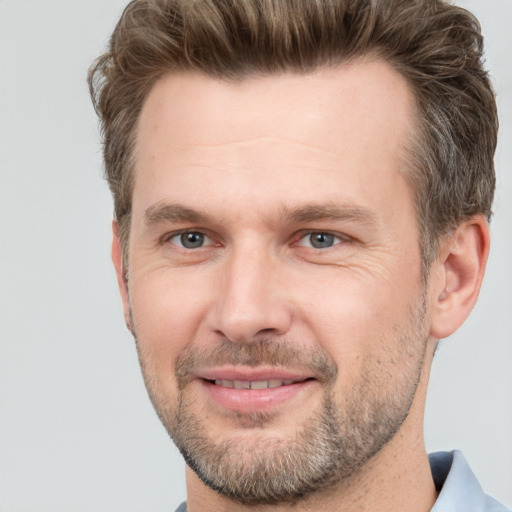 Joyful white adult male with short  brown hair and brown eyes