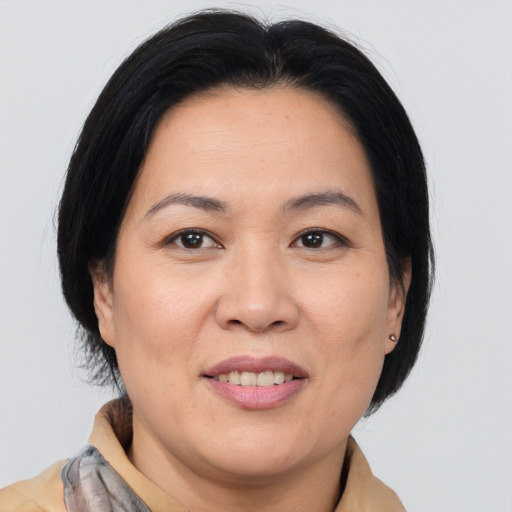 Joyful asian adult female with medium  brown hair and brown eyes