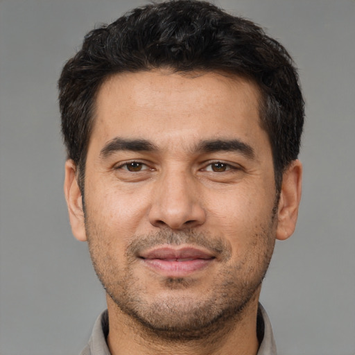 Joyful white young-adult male with short  black hair and brown eyes