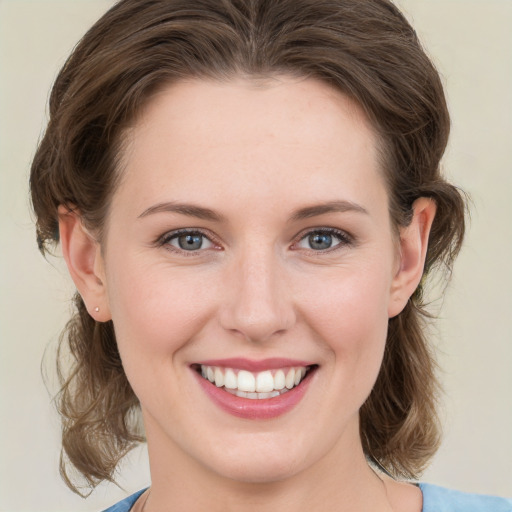 Joyful white young-adult female with medium  brown hair and grey eyes