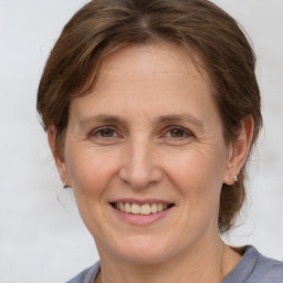 Joyful white adult female with medium  brown hair and grey eyes