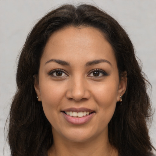 Joyful latino young-adult female with long  brown hair and brown eyes