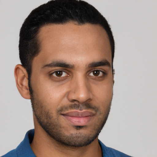 Joyful latino young-adult male with short  black hair and brown eyes