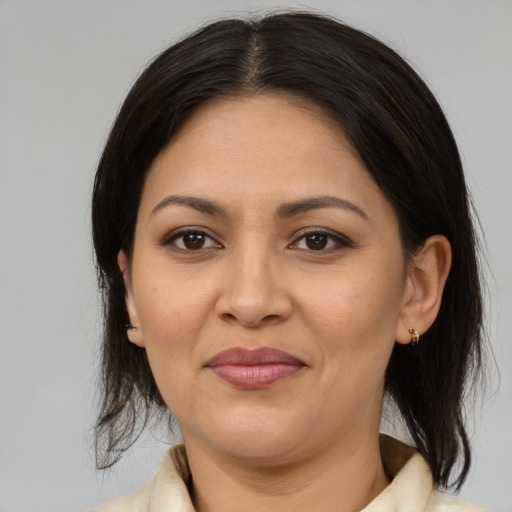 Joyful latino adult female with medium  brown hair and brown eyes