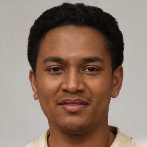 Joyful latino young-adult male with short  black hair and brown eyes