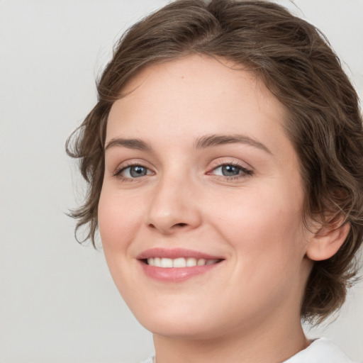 Joyful white young-adult female with medium  brown hair and green eyes