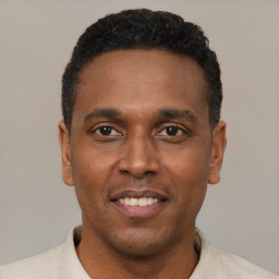 Joyful latino adult male with short  black hair and brown eyes