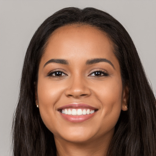 Joyful latino young-adult female with long  black hair and brown eyes