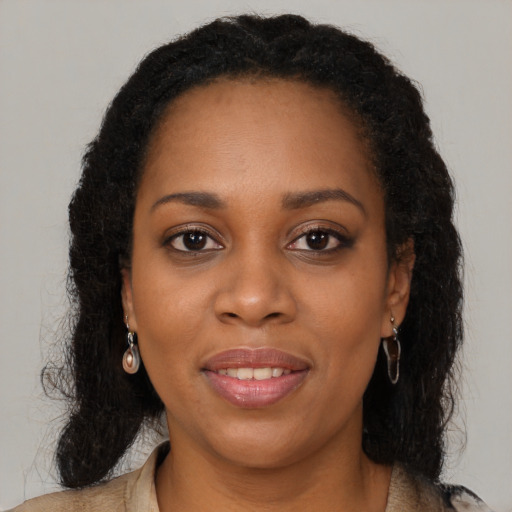 Joyful black young-adult female with long  brown hair and brown eyes