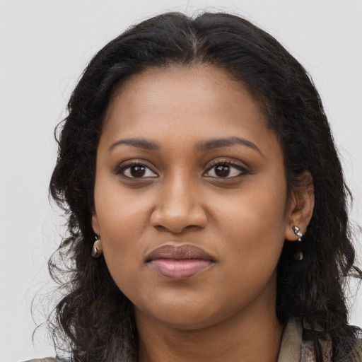 Joyful black young-adult female with long  brown hair and brown eyes