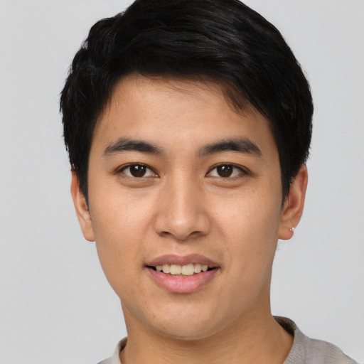 Joyful asian young-adult male with short  brown hair and brown eyes
