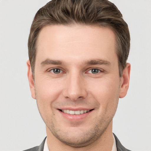 Joyful white young-adult male with short  brown hair and grey eyes