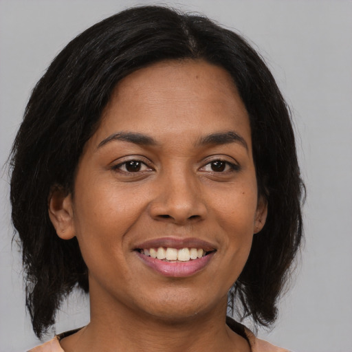 Joyful latino young-adult female with medium  brown hair and brown eyes